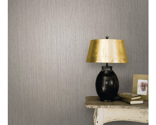 Prim-plan al unui perete cu tapet netesut și o lampă pe o masă