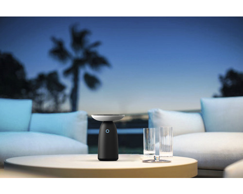 Lampă de masă pe masă cu pahare și canapea afară