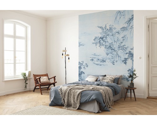 Dormitor cu fototapet albastru cu model, pat, lampă de citit și scaun din lemn