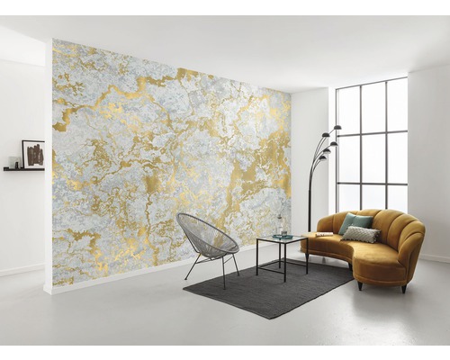 Cameră de zi cu tapet gri cu model auriu, scaun, canapea și masă