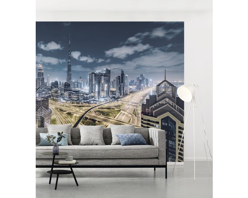 Cameră de zi cu fototapet cu orizontul orașului pe timp de noapte și canapea gri