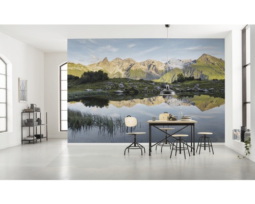 Cameră luminoasă cu fototapet cu peisaj montan și masă cu scaune