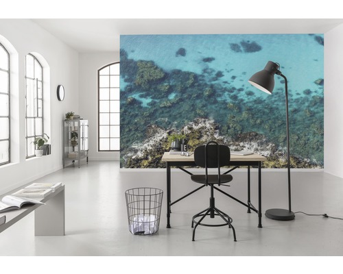 Cameră luminoasă cu birou, scaun, lampă de podea și fototapet cu motiv marin