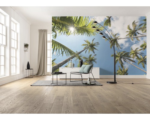 Living cu fototapet cu motiv de palmieri, lampă de podea, fotoliu și masă