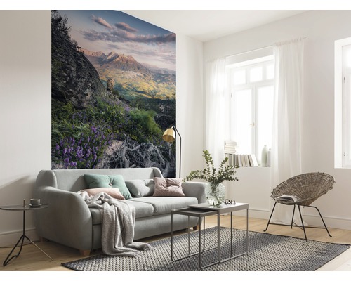 Living luminos cu canapea, covor și fototapet cu motiv montan