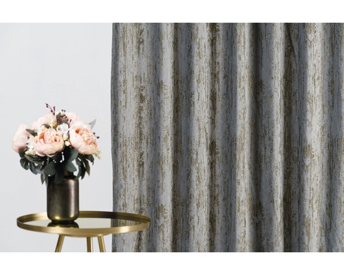 Perdea decorativă cu model structurat lângă o măsuță laterală cu o vază de flori