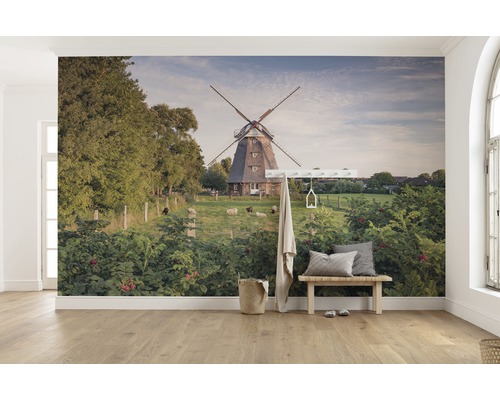 Pictură murală cu o moară de vânt, oi și verdeață luxuriantă într-o cameră luminoasă.