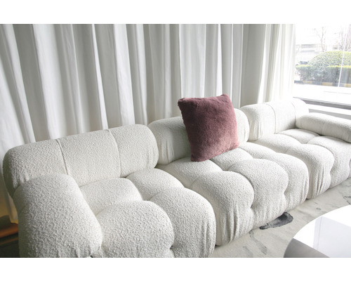 Canapea albă din material textil cu o pernă