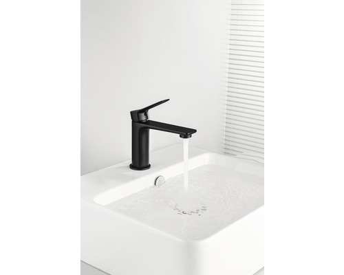 Baterie neagră de lavoar cu apă curgătoare într-o chiuvetă.