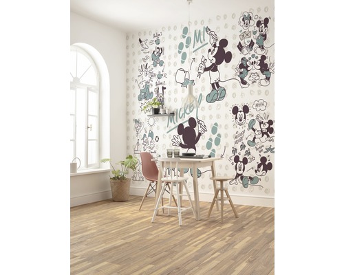 O sufragerie cu o masă, scaune și un perete cu motive Mickey Mouse.