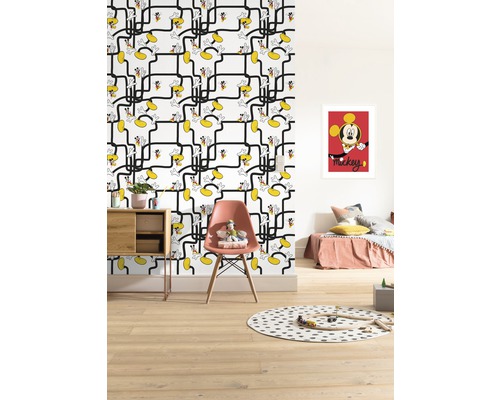 Cameră de copii cu tapet cu model Mickey Mouse, pat, scaun, masă și jucării