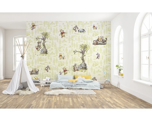 Cameră de copii cu un perete decorat cu tapet cu motive Winnie the Pooh, un cort teepee alb și un pat