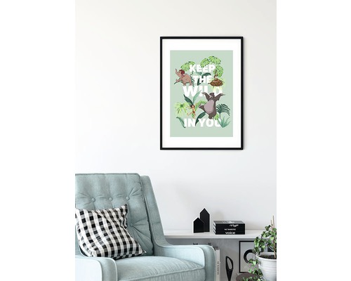 Poster înrămat cu Cartea Junglei cu inscripția Keep the Wild in You deasupra unui fotoliu