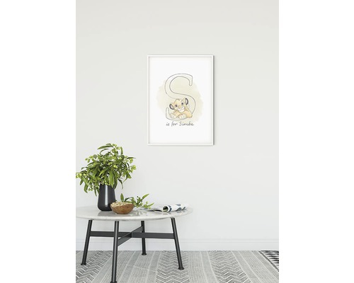 Poster înrămat cu litera S și Simba din Regele Leu pe un perete deasupra unei mese cu decorațiuni