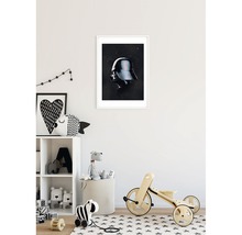 Poster decorativ cu motiv Darth Vader în ramă albă pe peretele din camera copilului.