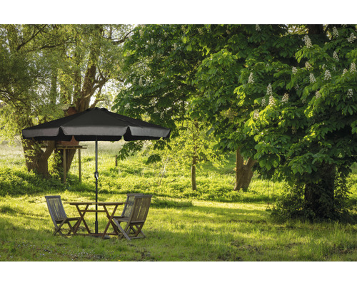 Scenă de grădină cu masă, scaune și umbrelă de soare pe un gazon verde