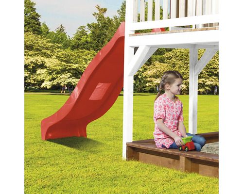 Loc de joacă cu tobogan roșu și fetiță în cutia cu nisip