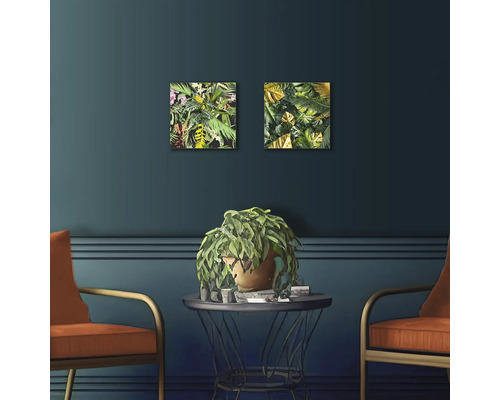 Spațiu de locuit decorativ cu două tablouri cu plante, masă, plantă la ghiveci și două scaune