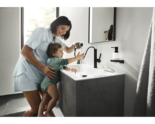 Mamă cu copil la chiuvetă cu baterie în baie