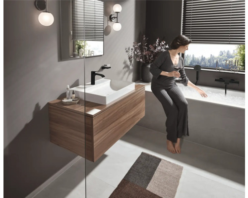 Baie luminoasă cu lavoar, oglindă, iluminat și cadă cu femeie