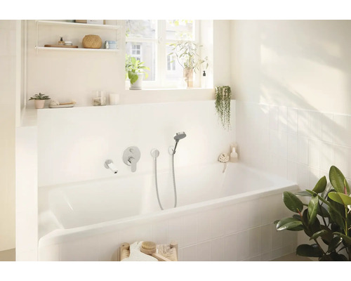 Baie luminoasă cu cadă, robinet și plante pentru o atmosferă relaxantă