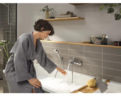 Baie cu cadă, robinet și femeie în halat de baie