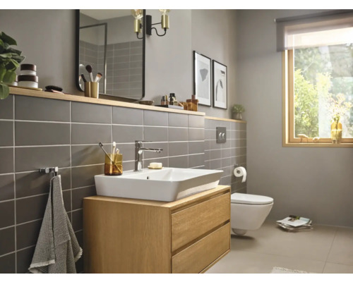 Baie luminoasă cu lavoar, oglindă, toaletă și fereastră pentru o atmosferă prietenoasă