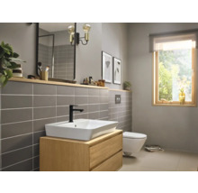 Baie luminoasă cu lavoar, oglindă, faianță și toaletă pentru un decor modern.