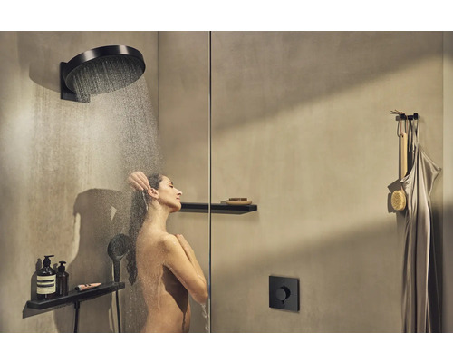 Femeie sub un duș cu efect de ploaie cu rafturi într-o baie