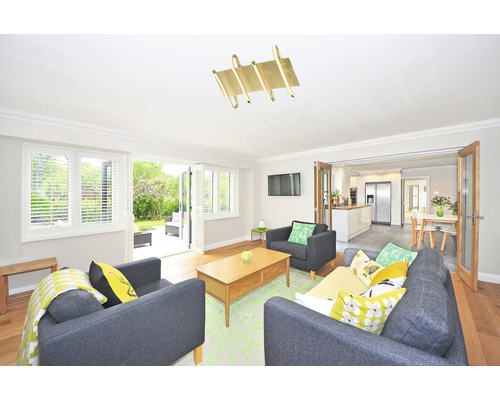 Cameră de zi cu canapele, măsuță de cafea și vedere la grădină