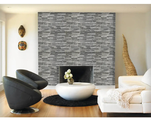 Living cu șemineu placat cu piatră, fotolii și decorațiuni.