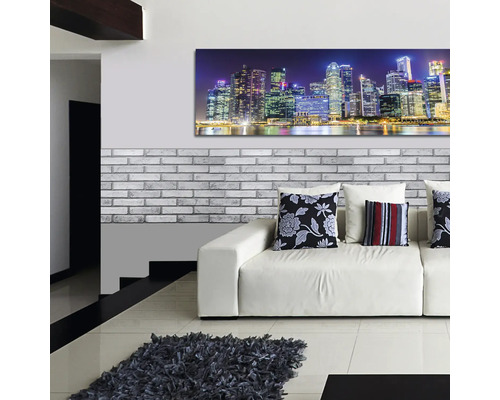 Living modern cu canapea, perne decorative, covor și pictură murală cu un oraș noaptea