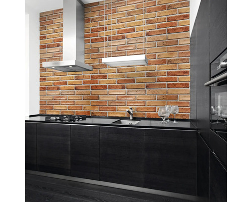 Bucătărie modernă cu perete din cărămidă, hotă și dulapuri negre.