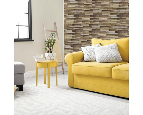 Living luminos cu canapea galbenă, perne decorative, măsuță laterală, plantă de interior și panouri de perete cu aspect de piatră.