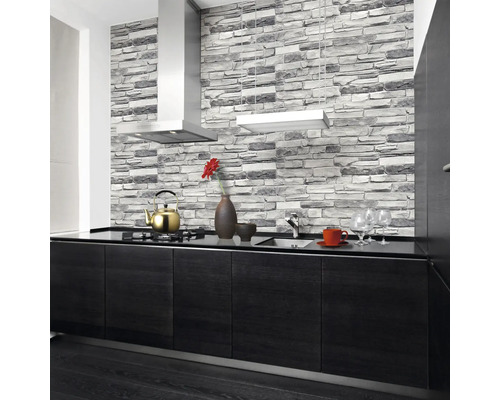 Bucătărie modernă cu tapet cu model de zid de piatră, hotă de aragaz și blat negru