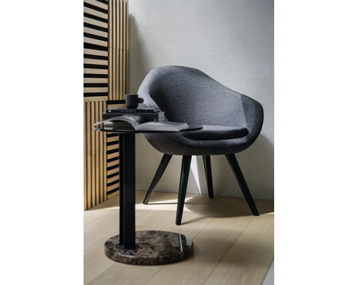 Fotoliu din material textil lângă o măsuță laterală cu blat rotund