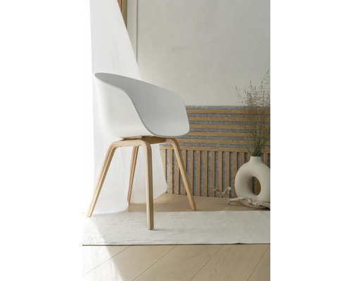 Scaun alb cu brațe și picioare din lemn în spațiul de locuit.