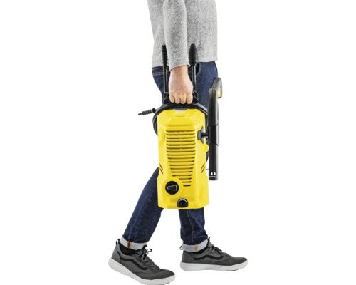 O persoană poartă un aparat de curățat cu presiune înaltă galben.