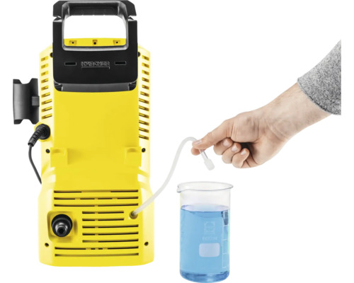 Aparat de curățat cu presiune Kärcher cu furtun de aspirație într-un pahar gradat cu lichid