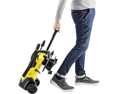 Aparat de curățat cu presiune galben și negru tras de o persoană