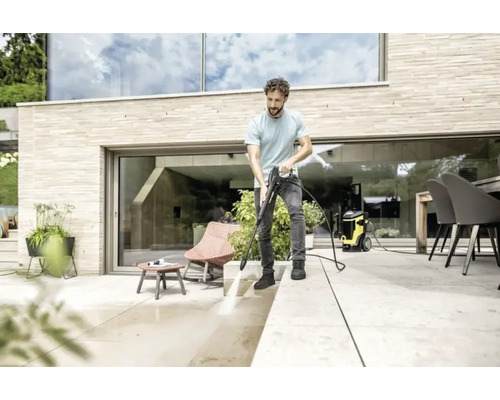 Bărbat curățând terasa cu un curățător cu presiune