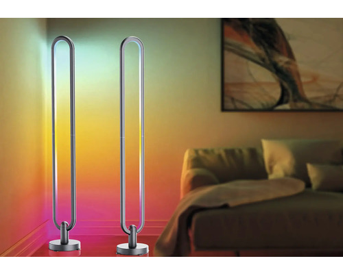 Două lampadare metalice în sufragerie cu iluminare colorată.