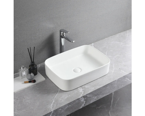 Lavoar ceramic dreptunghiular montat pe blat cu robinet pe un blat