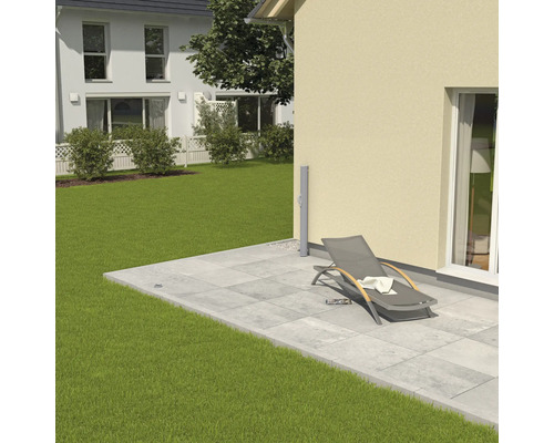 Terasa cu plăci de piatră, șezlong și gazon în grădină