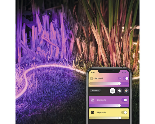 Bandă luminoasă cu LED iluminează o grădină, controlată printr-o aplicație de smartphone.