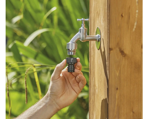 Mână conectează conectorul furtunului la robinet