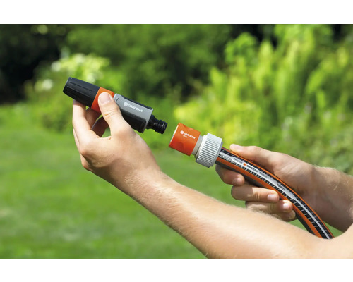 Persoană care conectează un conector de furtun de grădină la un furtun de grădină