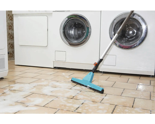 Mop cu racletă în fața mașinilor de spălat pe podea cu gresie