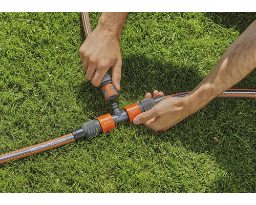 Scenă de irigare a grădinii cu racord în T și racorduri de furtun pe gazon