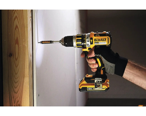 Mașină de găurit și înșurubat cu acumulator Dewalt în timpul utilizării pentru înșurubarea într-un perete